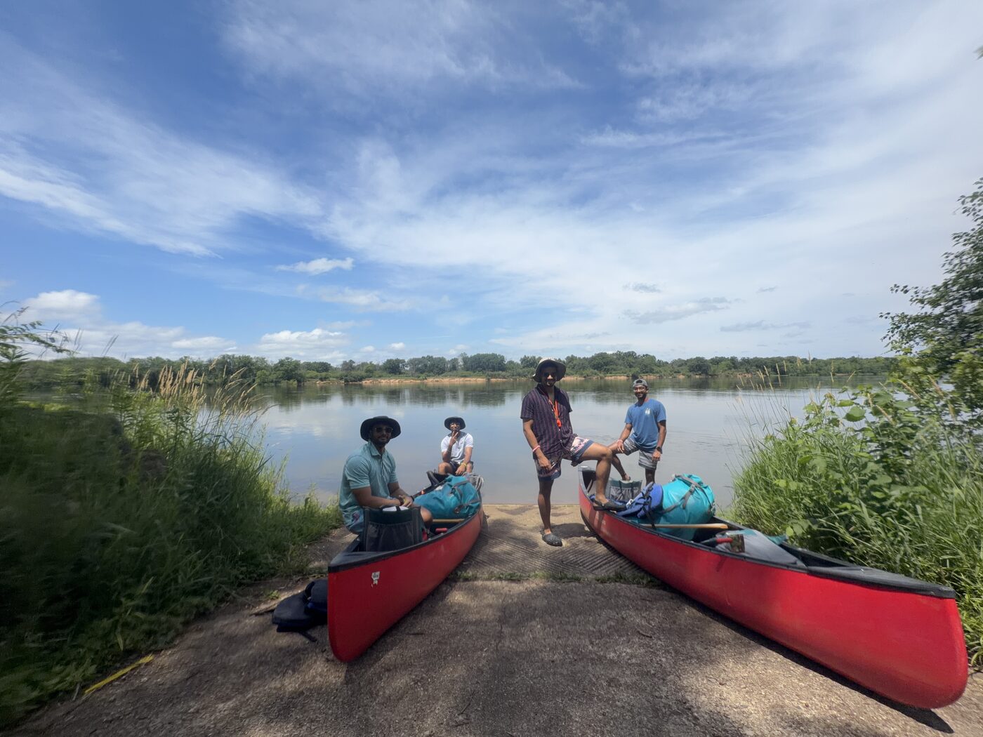 Akshat and friends with canoes on a river during an outdoor trip.