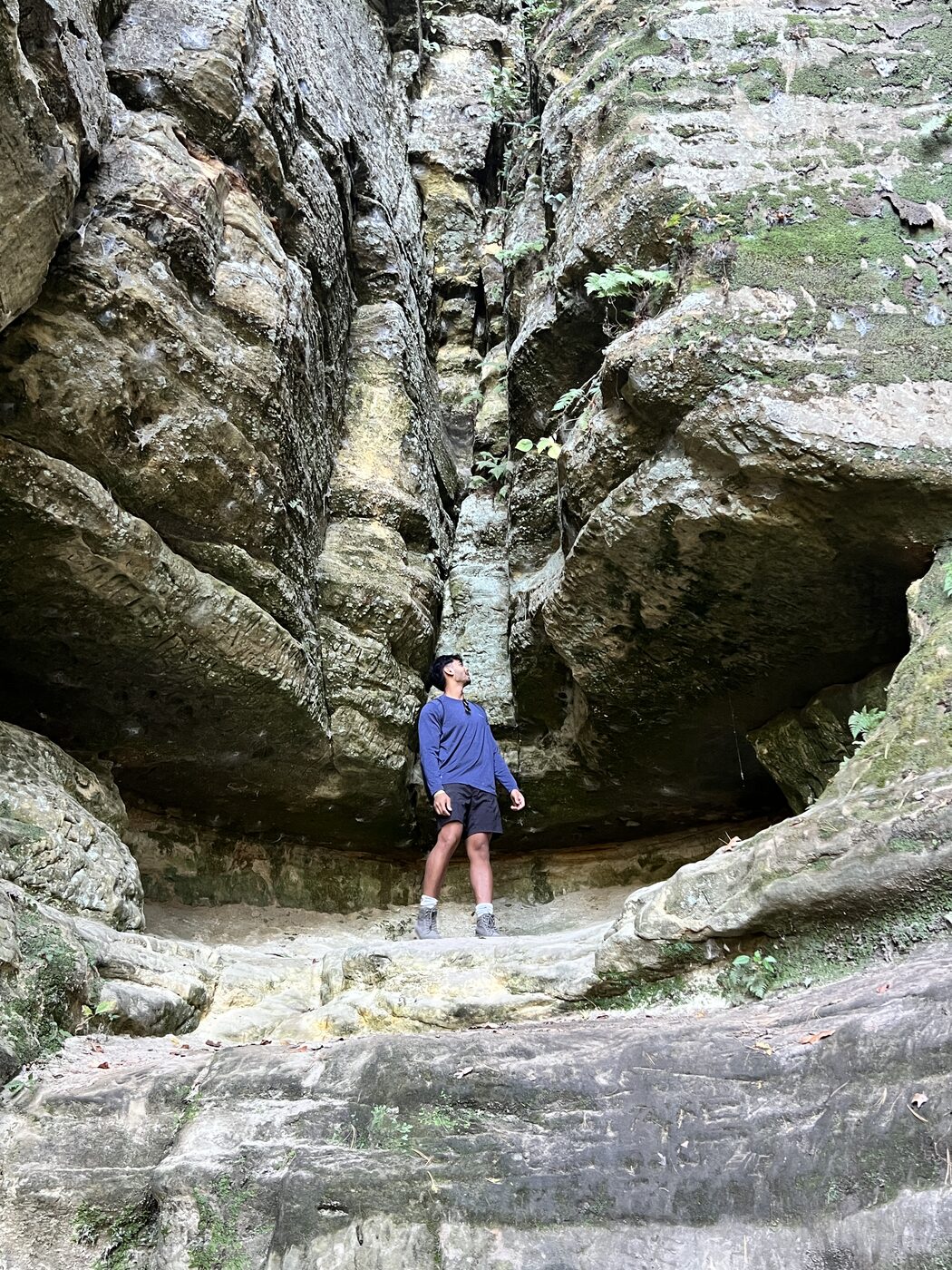 Akshat exploring a rock formation on a hike.