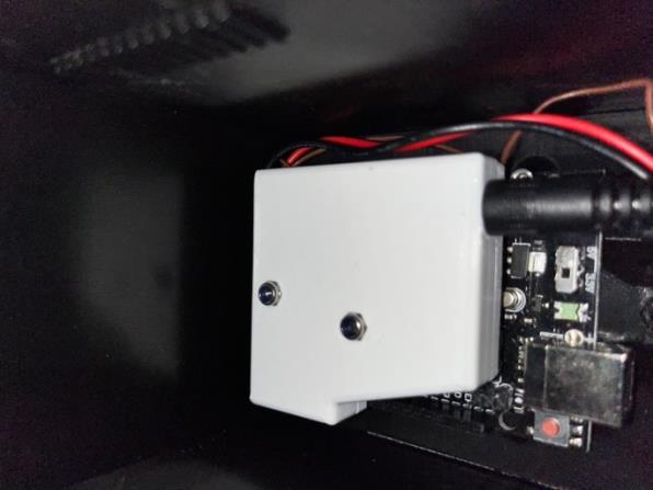 Close-up of the white 3D-printed enclosure component mounted to the Arduino and heater assembly inside the device.
